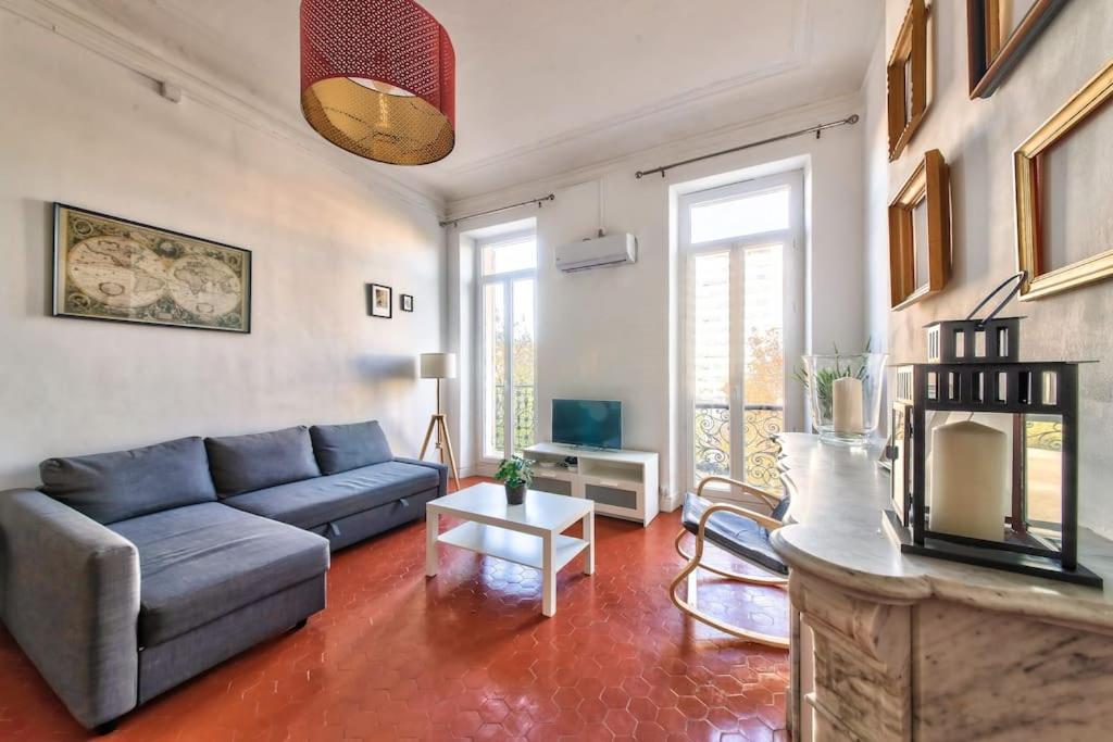 马赛Superbe appartement de 110 m² au cœur de Marseille的客厅设有蓝色的沙发和壁炉