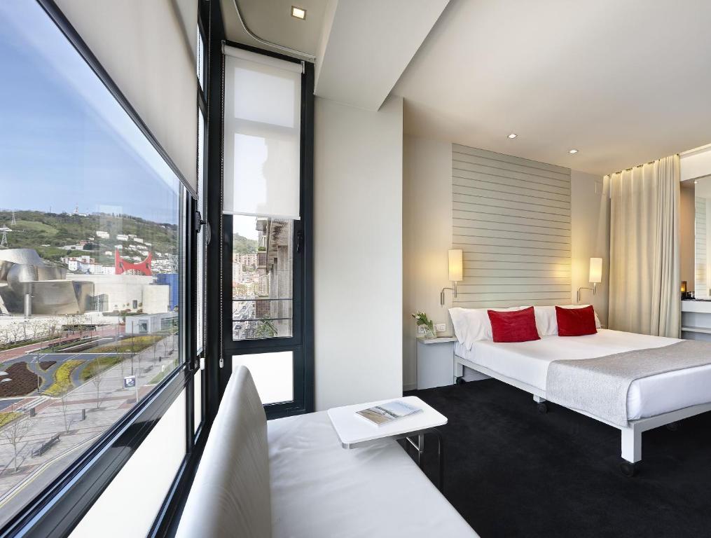 毕尔巴鄂米罗酒店的一间卧室设有一张床和一个大窗户