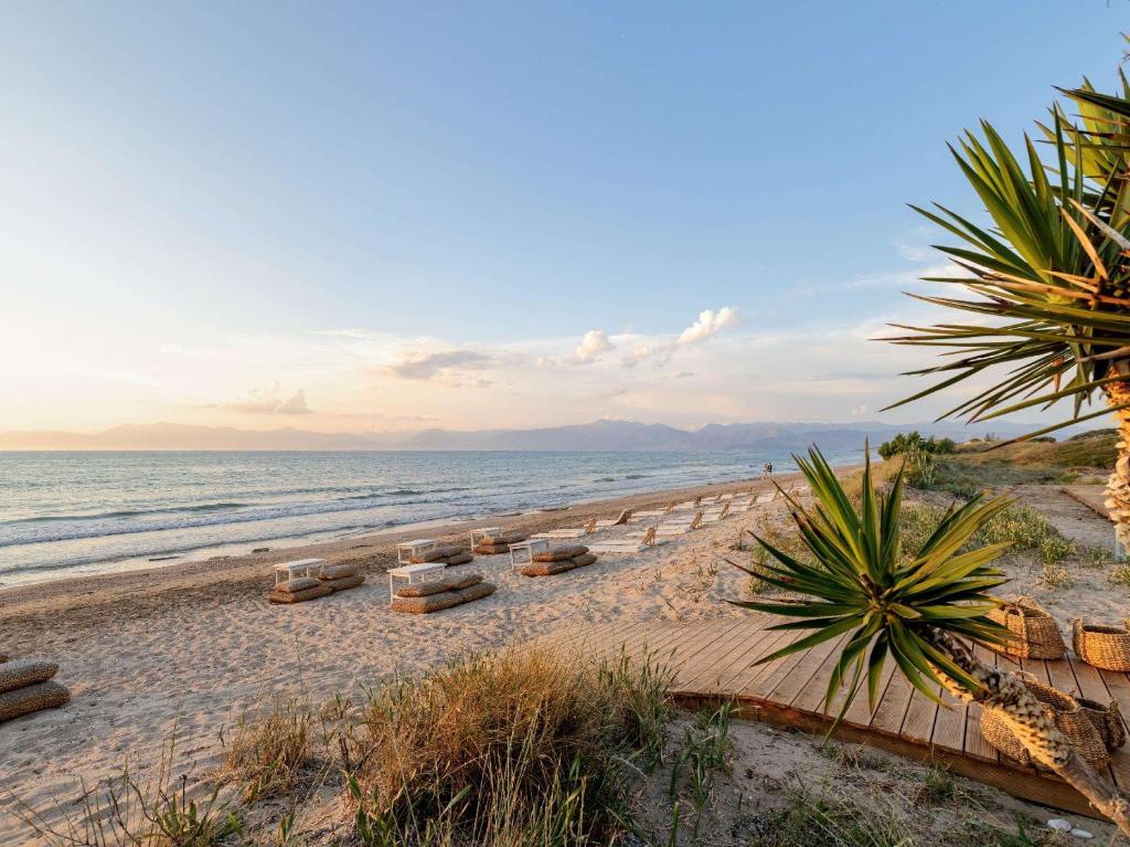 阿查拉维Grecotel-LUXME Costa Botanica的海滩上设有躺椅,大海上设有躺椅