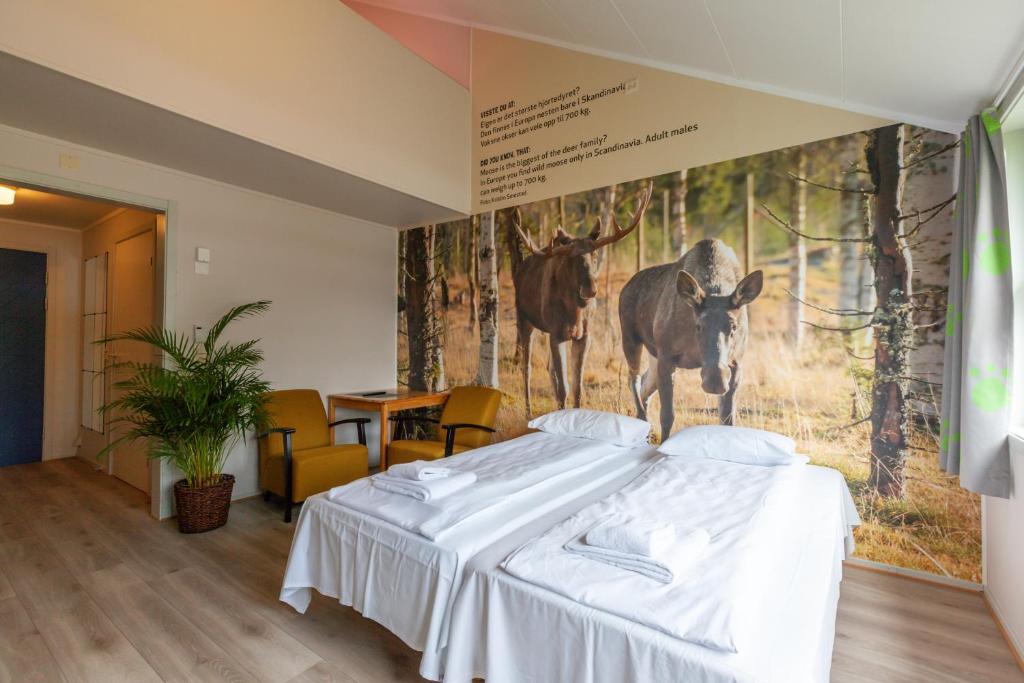 TronesNamsskogan Familiepark & Hotell的卧室配有一张床铺,墙上挂着鹿的照片