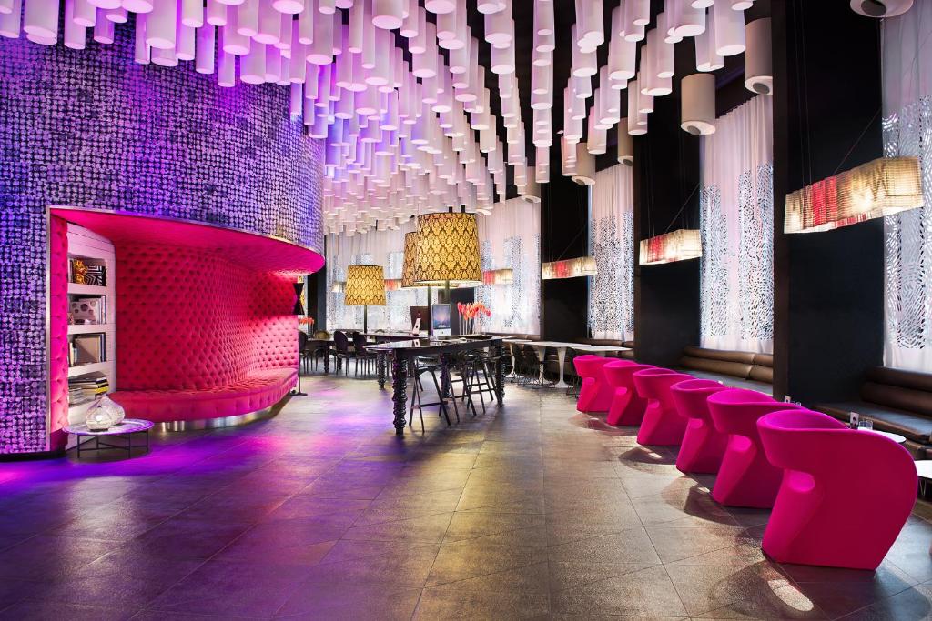 巴塞罗那Barceló Raval的一间用餐室,配有粉红色的椅子和紫色的灯光