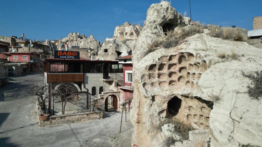 内夫谢希尔Babili Cappadocia Cave Hotel的岩石山边的建筑