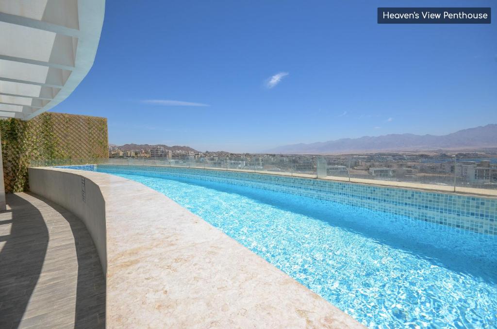 埃拉特YalaRent mountainside luxury Hotel apartments with Private Pool Eilat的大楼内的一个蓝色海水游泳池