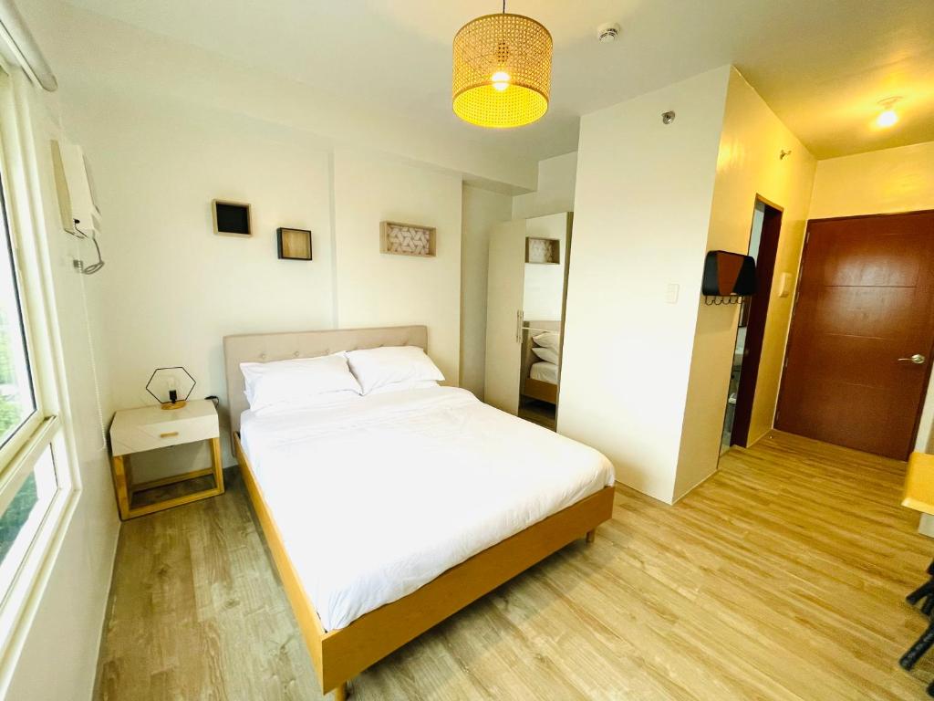 巴科洛德Cozy Condo bedroom in Bacolod City的卧室设有一张白色大床和一扇窗户。