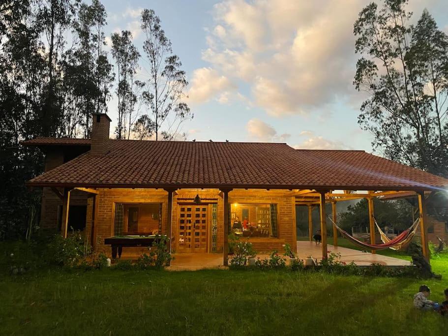 昆卡Casa de campo rústica en Cuenca的田野上一所棕色屋顶的小房子
