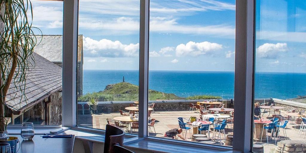 圣贾斯特Cape Cornwall Club的从餐厅窗口可欣赏到海景