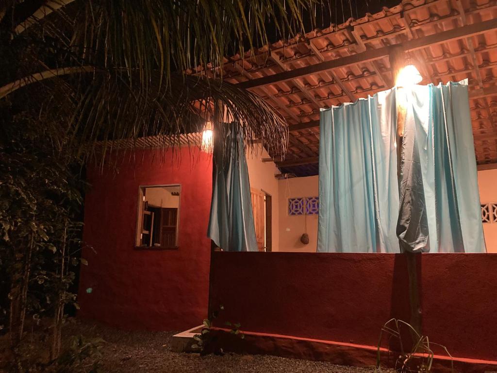 伊塔卡雷Casa Vila Camboinha的一间设有蓝色窗帘和红色墙壁的客房