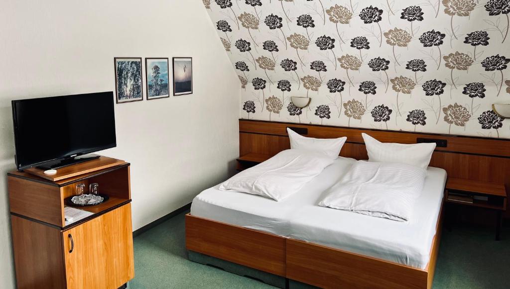 伦讷施塔特拉尔曼兰德酒店的一间卧室配有一张床和一台平面电视
