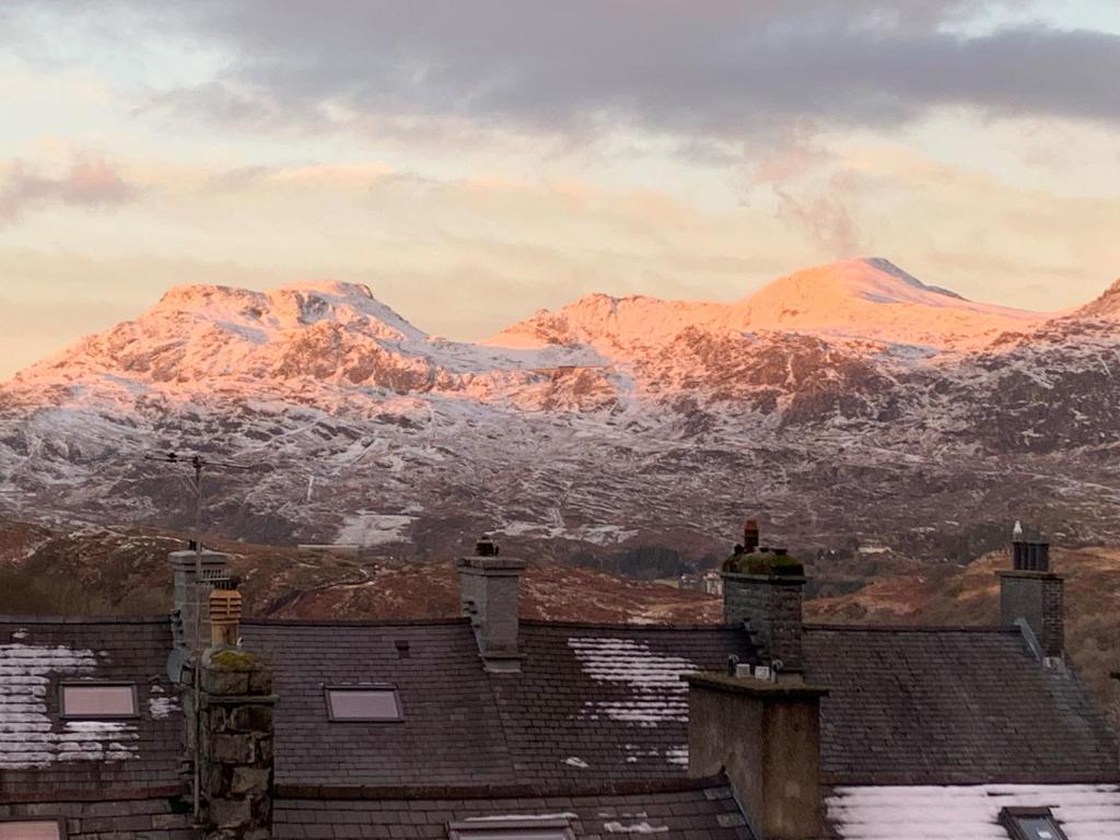 布莱奈费斯蒂尼奥格Cosy cottage in picturesque Snowdonia with stunning views of the Moelwyn mountains的从房屋屋顶可欣赏到雪覆盖的群山景色