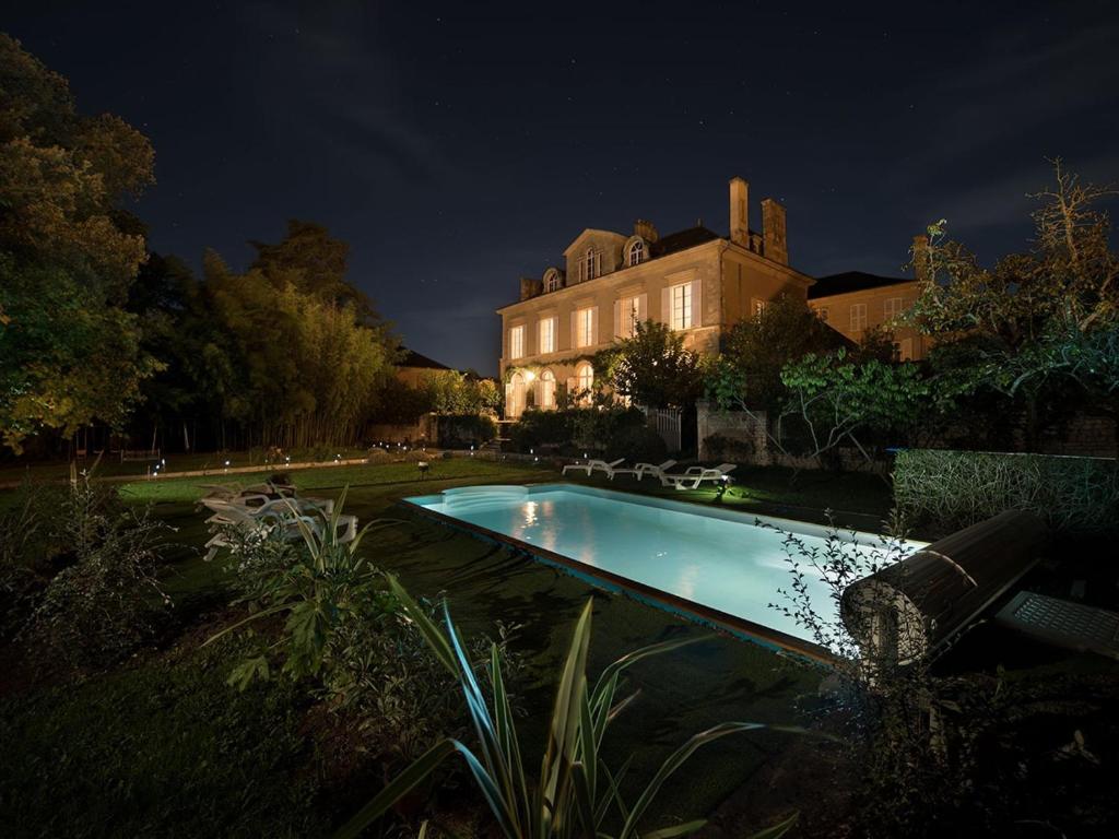 丰特奈勒孔特Chambre d'hotes La maison de Maître的夜间在房子前面的游泳池