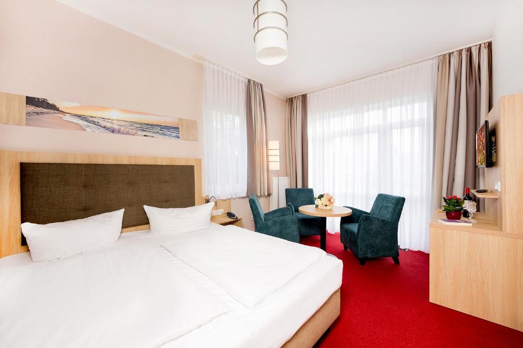 塞巴特阿尔贝克Hotel Garni Sonne的酒店客房带一张床、一张桌子和椅子