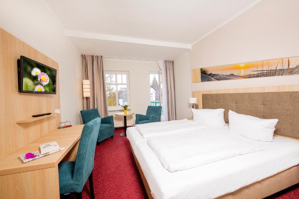 塞巴特阿尔贝克佳妮艾登酒店的酒店客房设有一张大床和一张书桌。