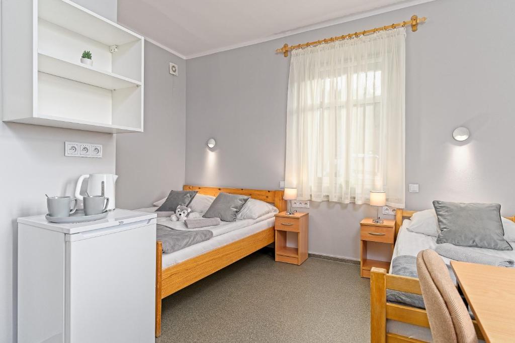 科瓦雷Ośrodek WOJKÓW Kowary koło Karpacza的一间带两张床和一张桌子的卧室以及一间厨房