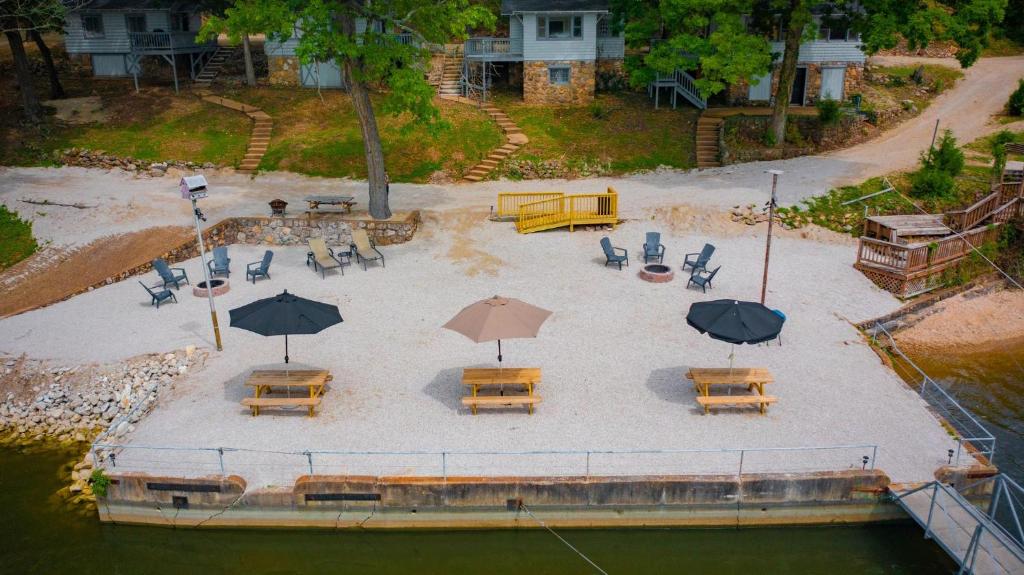奥沙克湖Lakeshore Fishing Cabins #4的享有带桌子和遮阳伞的庭院的空中景致