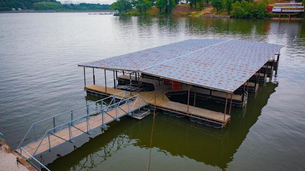 奥沙克湖Lakeshore Fishing Cabin #12 , dock/boat slip/ramp on location的水上浮动码头,设有太阳能屋顶