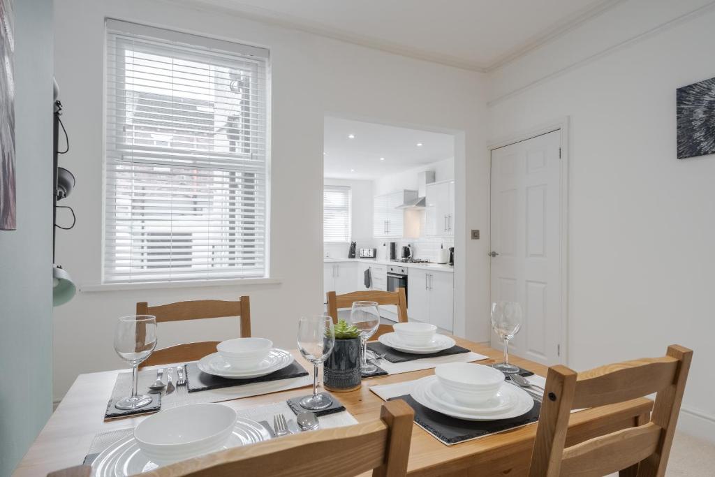 利物浦Denebank Lodge - Anfield Apartments的一间带桌椅的用餐室和一间厨房