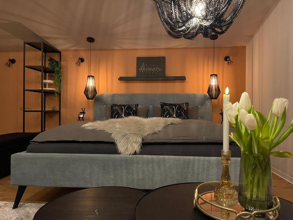威斯巴登Stay at Smilla - Boutique Apartments mit Küche - Parken - Klima - Netflix - Waschmaschine的一间卧室配有一张带灰色床罩和桌子的床。