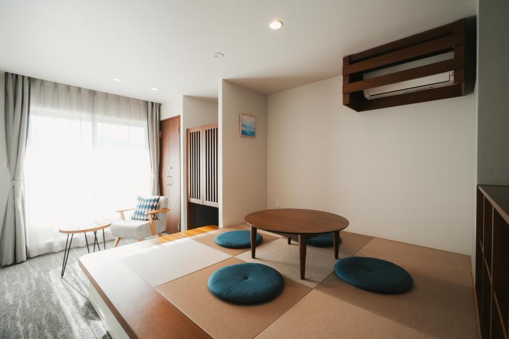 广岛LAZULI Hiroshima Hotel and Lounge的客厅配有桌子和2把蓝色椅子