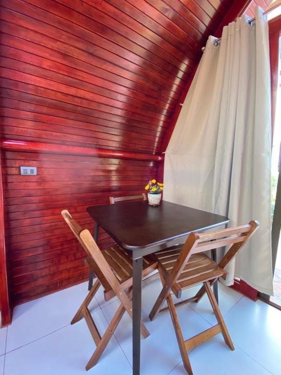 迦太基Glamping Campo Alegre的木墙客房内的桌椅