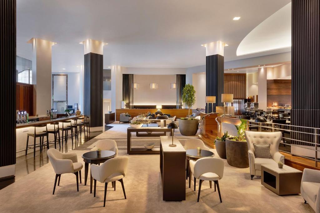奥克兰奥克兰 JW 万豪酒店的酒店大堂设有桌椅和酒吧
