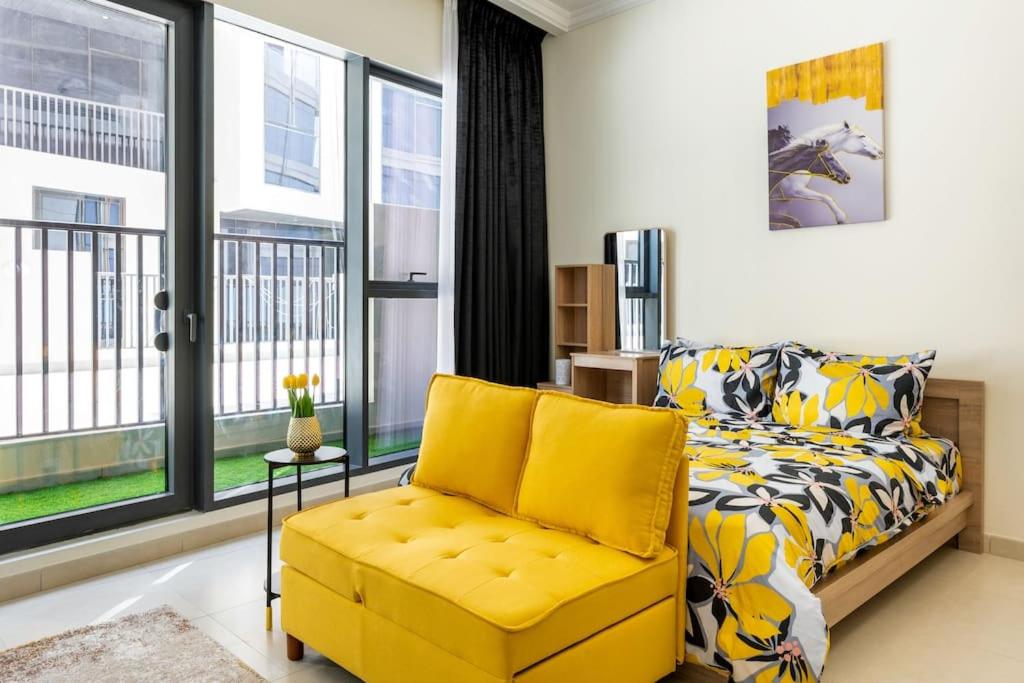 迪拜Brand New Studio Near Dubai Airport的一间卧室配有黄色的沙发和黄色的椅子