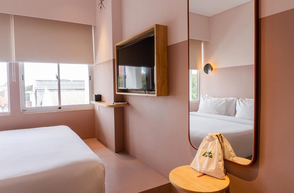 三宝垄Kotta Hotel Semarang的酒店客房,设有两张床和镜子