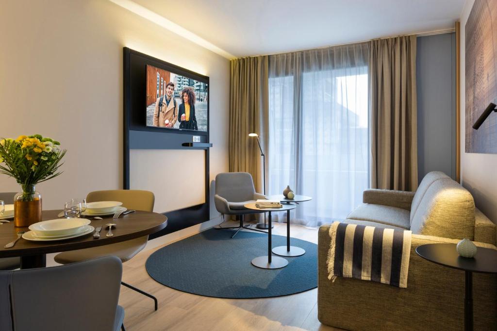 库尔布瓦馨乐庭巴黎德芬斯酒店的客厅配有沙发和桌子