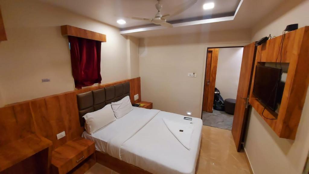 孟买HOTEL RIGGA INN KOKILABEN DHIRUBHAI AMBANI Hospital的一间小卧室,配有一张床和一台平面电视
