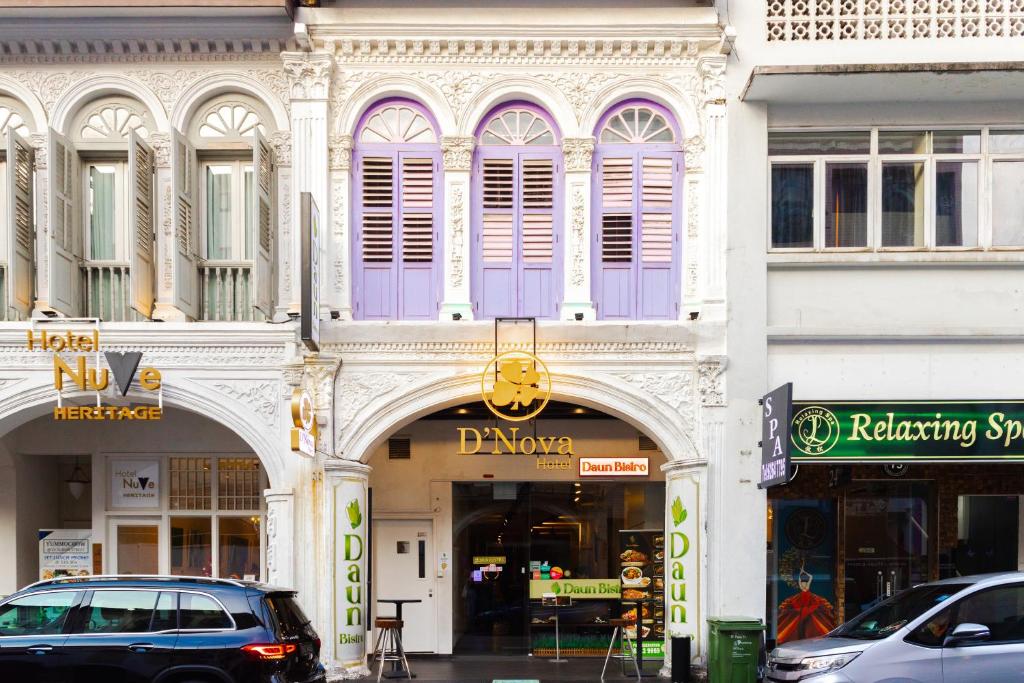 新加坡D'Nova Hotel Bugis的一条有紫色门和汽车停在街上的建筑