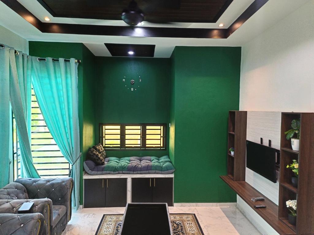 Pasir MasQs Family Homestay Pasir Mas的客厅设有绿色的墙壁和沙发