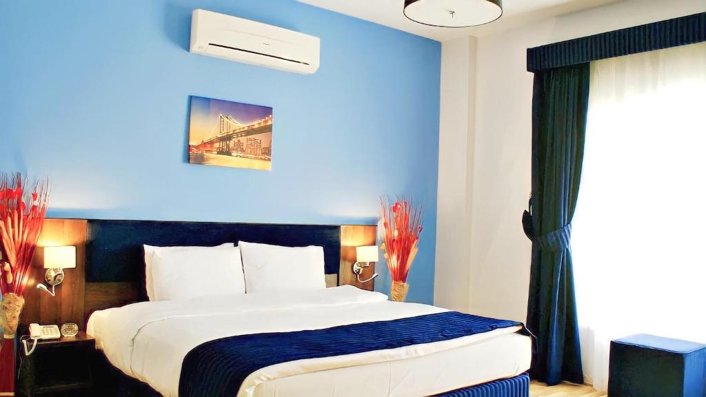 马斯喀特Weekdays Hotel的一间卧室设有一张蓝色墙壁的大床