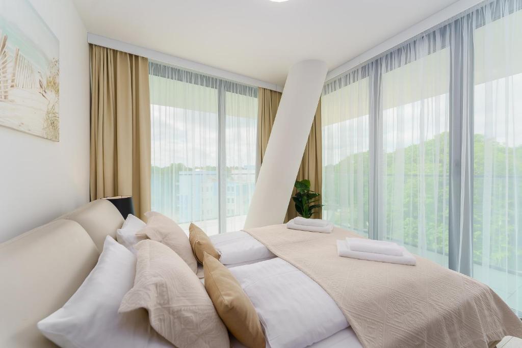 米兹多洛杰Sea Waves Apartament Resort & SPA 428B by Renters的一间卧室设有一张大床和大窗户