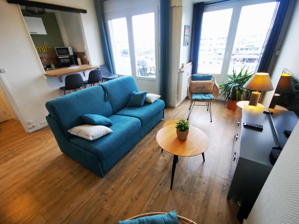 加来Le Smile的客厅配有蓝色的沙发和桌子