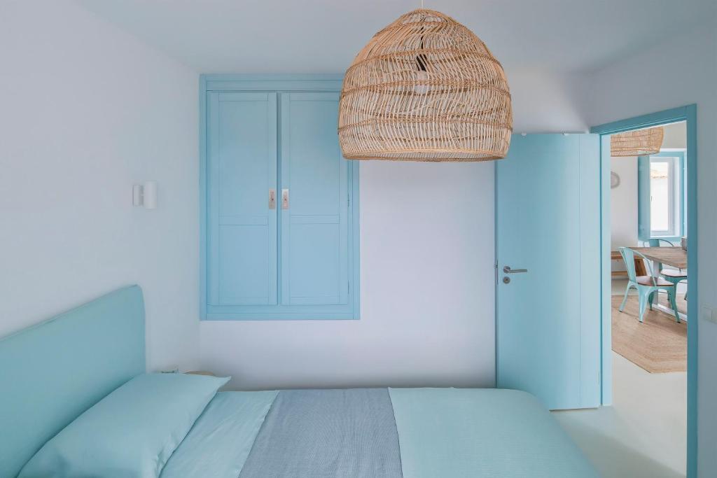 萨尔堡Casa Azul do Olival的一间卧室配有床和柳条篮