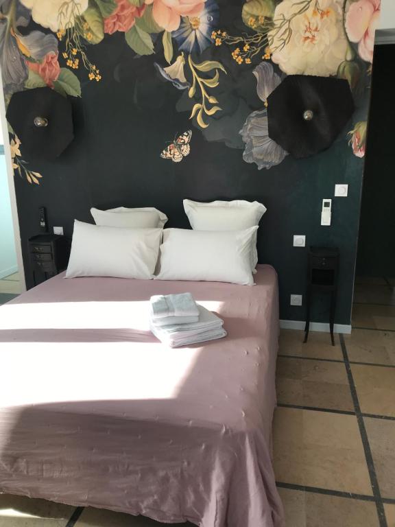 Saint-HippolyteLA CASA SANILLS的卧室配有一张墙上鲜花的床