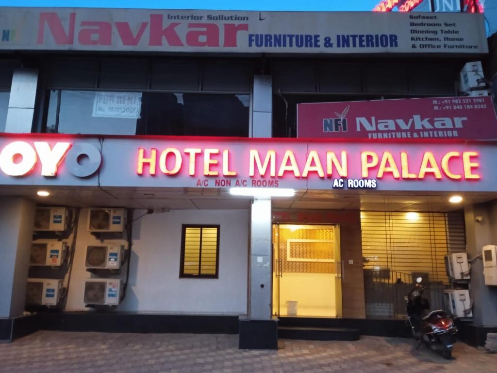 艾哈迈达巴德Hotel Maan Palace的一座酒店大厦,前面有标志