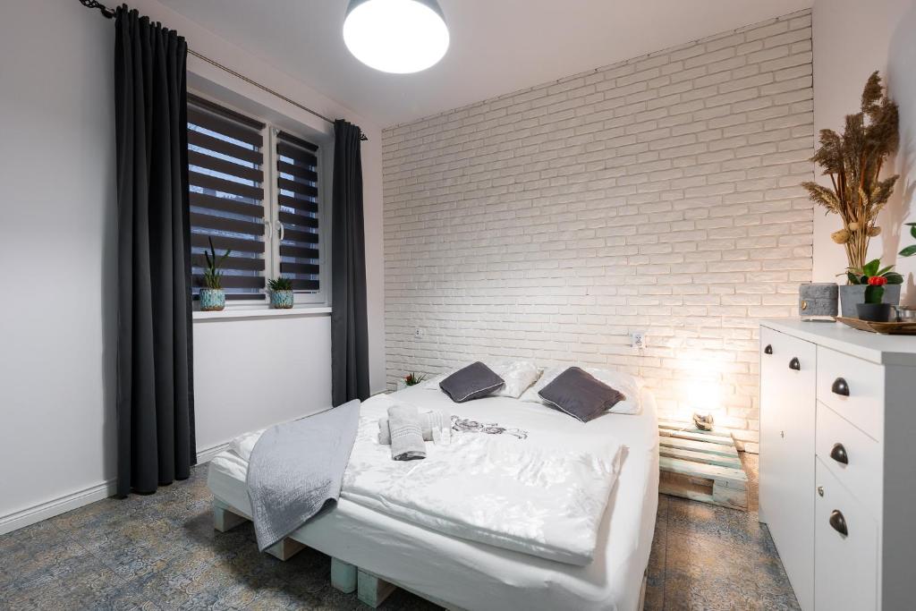 鲁达希隆斯卡Apartament Południowy的卧室配有白色的床和砖墙