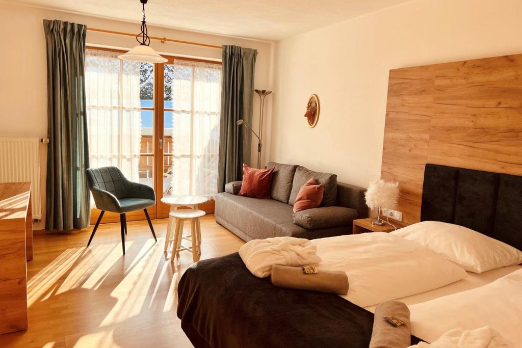 巴特科尔格鲁布Wellnesshotel Waldruh的一间卧室配有一张床,客厅配有沙发