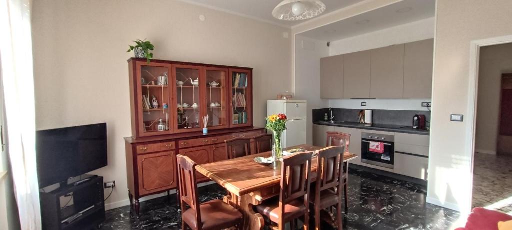 帕尔马La Casa di Amelie的厨房配有木桌、椅子和冰箱