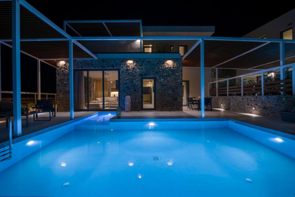 卡拉塔斯Xenias Luxury Villas的游泳池,后方是一座房子