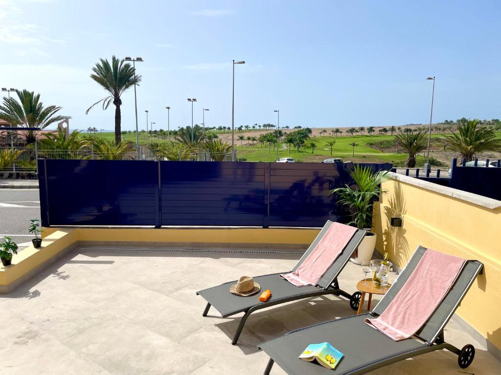 梅罗那瑞斯Bahia Meloneras Vista Golf的庭院设有两把椅子,享有沙漠美景
