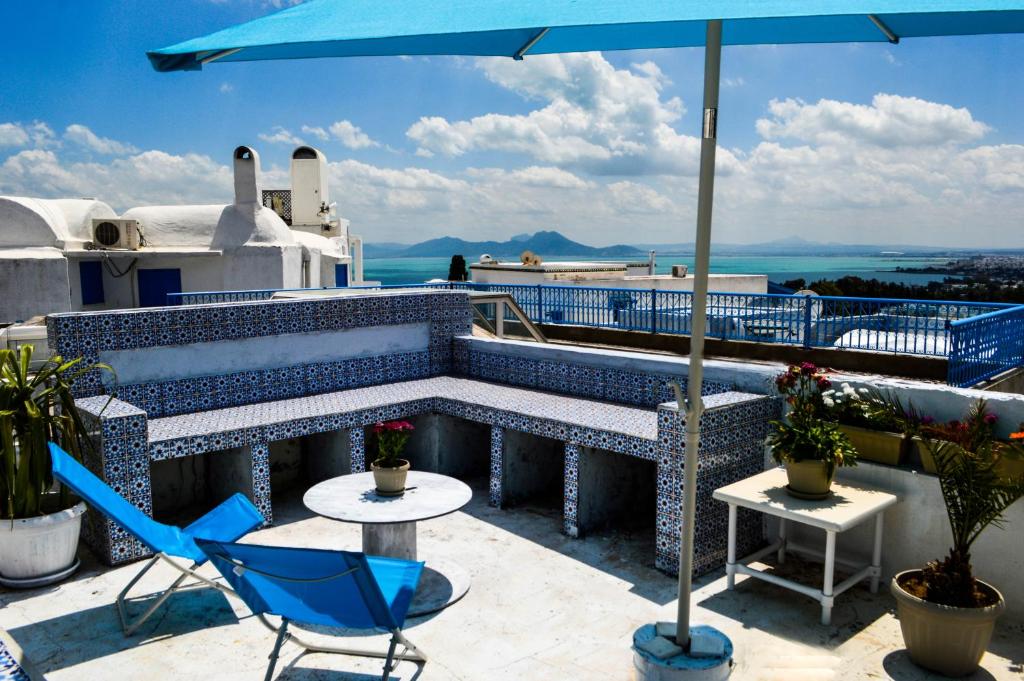 西迪·布·赛义德Cosy S3 Apartment in Sidi Bou Said Village的庭院配有桌椅和遮阳伞。