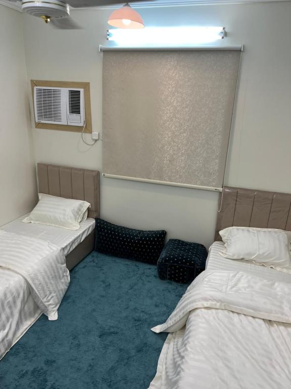 乌姆莱季AlSultan Apartments的客房设有两张床和窗户。