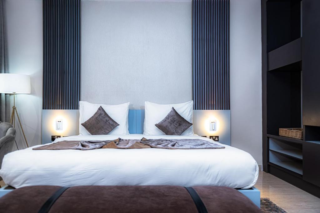 阿布贾Wali's Suites的卧室配有一张带白色床单和枕头的大床。