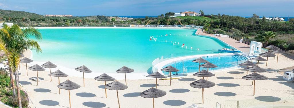 Estepona2152-Modern apt with private beach的享有带遮阳伞的游泳池和海滩的景致。