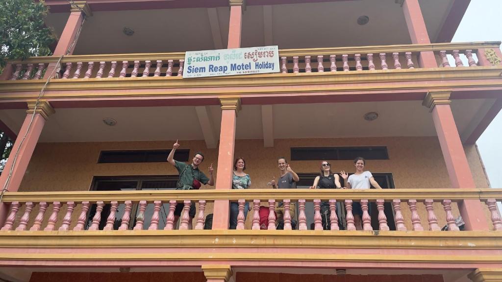 暹粒Siem Reap Holiday Guest House or Motel的站在建筑物阳台的一群妇女
