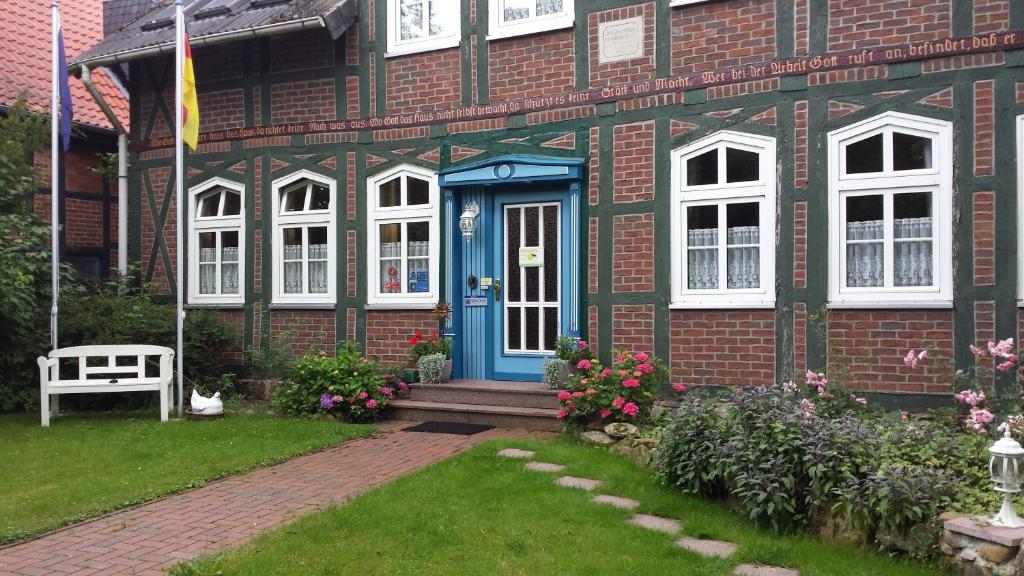 ClenzeLandhotel Sonnenhof im Wendland的一间设有蓝色门和白色窗户的砖房