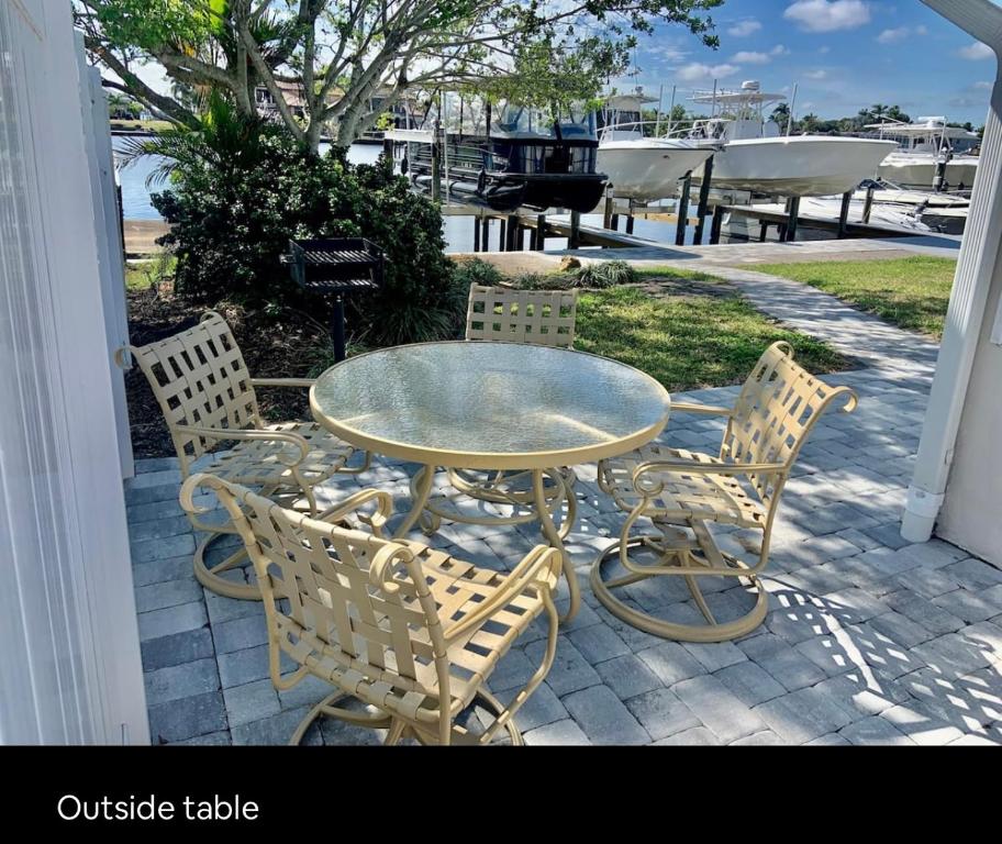 珊瑚角Cheerful home with one bedroom的露台上的玻璃桌子和椅子