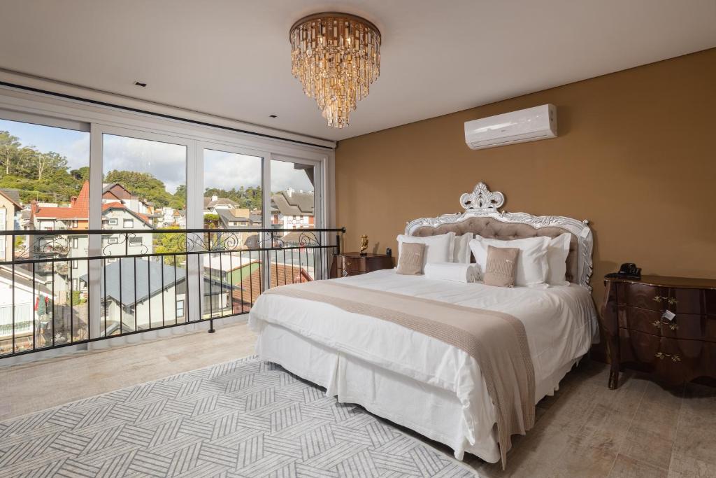 格拉玛多Hotel Fioreze Centro的一间卧室配有一张床,阳台配有吊灯。