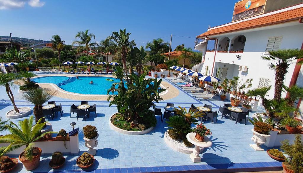 圣多米尼卡达曼斯酒店的一个带游泳池和桌椅的度假酒店
